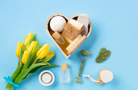 Natural eco friendly beauty skin care products, spa accessories for women and spring tulip flowers on blue background. Zero waste self care heart shape gift box for Mothers day, womans day, birthday.の写真素材