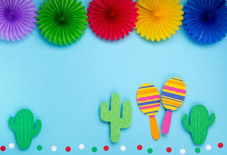 Mexican background fiesta with Traditional Mexican nachos chips, red chilli pepper, cactus and maracas on blue background. Cinco de Mayo (Fifth of May) celebration concept. Top view, copy space.の写真素材