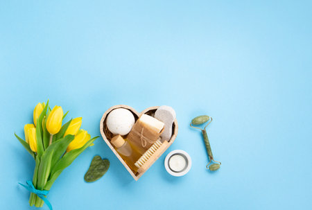 Natural eco friendly beauty skin care products, spa accessories for women and spring tulip flowers on blue background. Zero waste self care heart shape gift box for Mothers day, womans day, birthday.の写真素材