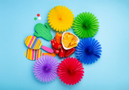 Mexican background fiesta with Traditional Mexican nachos chips, red chilli pepper, cactus and maracas on blue background. Cinco de Mayo (Fifth of May) celebration concept. Top view, copy space.の写真素材