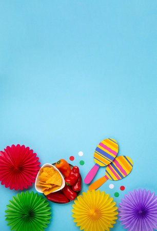 Mexican background fiesta with Traditional Mexican nachos chips, red chilli pepper, cactus and maracas on blue background. Cinco de Mayo (Fifth of May) celebration concept. Top view, copy space.の写真素材