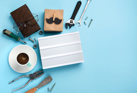 Fathers day holiday card concept with craft gift box, black mustache, cup of coffee, tools, book,...