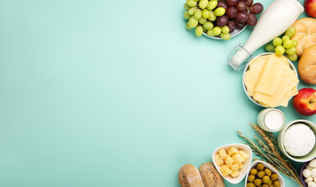 Happy Shavuot holiday card. Jewish religious holiday concept. Dairy products, fruits, cheese, bread, milk bottle, cottage cheese, wheat on blue mint background. Top view, copy space.の写真素材