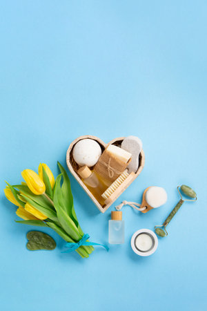 Natural eco friendly beauty skin care products, spa accessories for women and spring tulip flowers on blue background. Zero waste self care heart shape gift box for Mothers day, womans day, birthday.の写真素材