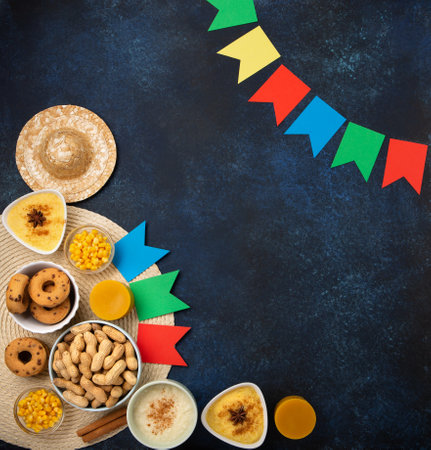 Festa Junina Summer Festival Carnival concept. Brazilian straw hat, Corn Cakes, peanuts and colorful flags on wooden blue background, top view. Design for Greeting Card, Invitation or Holiday Posterの写真素材