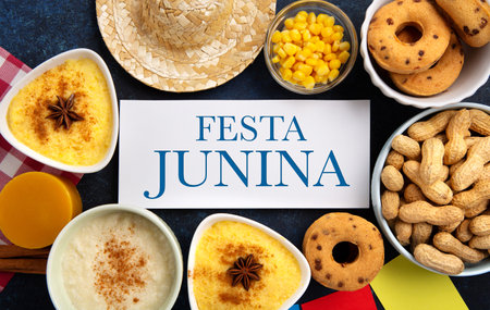 Festa Junina Summer Festival Carnival concept. Brazilian straw hat, Corn Cakes, peanuts and colorful flags on wooden blue background, top view. Design for Greeting Card, Invitation or Holiday Posterの写真素材