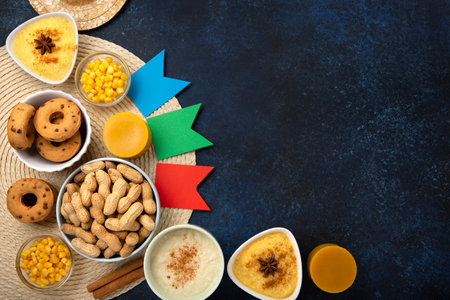 Festa Junina Summer Festival Carnival concept. Brazilian straw hat, Corn Cakes, peanuts and colorful flags on wooden blue background, top view. Design for Greeting Card, Invitation or Holiday Posterの写真素材