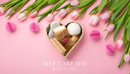 Happy Self Care Day. Natural eco friendly beauty skin care products, spa accessories for women and spring tulip flowers on pink background. Self care heart shape gift box. concept of me timeの写真素材
