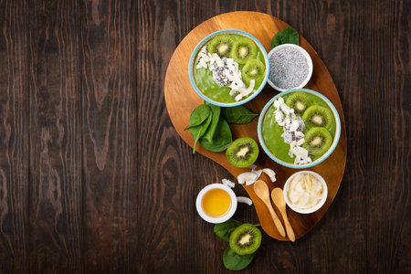 Green smoothie bowl with organic Spinach, Banana, Chia Seeds, fresh kiwi on dark wooden background. Vegan, Food and drink, healthy dieting and nutrition, alkaline, vegetarian concept.の写真素材