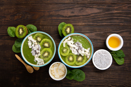 Green smoothie bowl with organic Spinach, Banana, Chia Seeds, fresh kiwi on dark wooden background. Vegan, Food and drink, healthy dieting and nutrition, alkaline, vegetarian concept.の写真素材