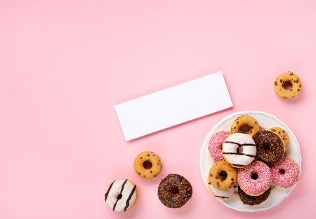 Holiday colorful Donuts donuts with chocolate and sugar sprinkles on pink background, top view. Festive carnival or birthday party card. Happy National donut day Concept.の写真素材