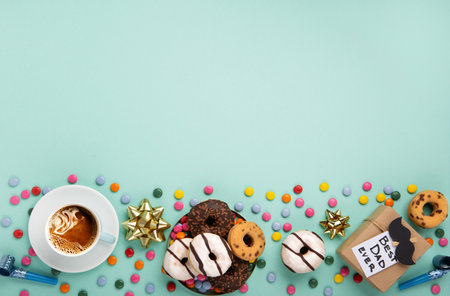 Fathers day holiday card concept with craft gift box, black mustache, cup of coffee and donuts or donuts on blue mint background, top view, copy space.の写真素材