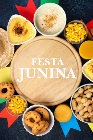 Festa Junina Summer Festival Carnival concept. Brazilian straw hat, Corn Cakes, peanuts and colorful flags on wooden blue background, top view. Design for Greeting Card, Invitation or Holiday Posterの写真素材