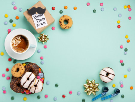 Fathers day holiday card concept with craft gift box, black mustache, cup of coffee and donuts or donuts on blue mint background, top view, copy space.の写真素材