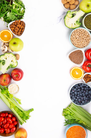 Concept of healthy Vegan lifestyle, balanced food, nutrition, clean eating food. Fresh ingredients for dietary, vegetables, fruits, nuts for weight loss on white table. Healthy background, top view.の写真素材