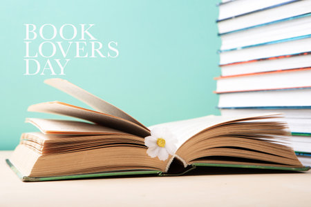 Book Lovers Day, Education concept. Stack of books and open book on blue mint background. Festive card for books holiday, copy space.の写真素材