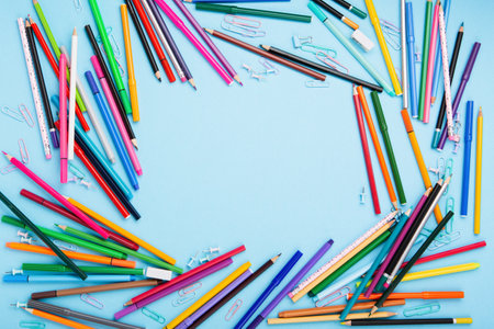 Back to school, Exam, Education concept on blue background. School scattered stationery, notepads, pens, pencils, paper clips on blue table. Top view, copy space.の写真素材