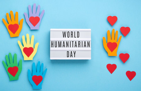 World Humanitarian Day Concept. Tolerance, kindness, cooperative, friendship, charity, humanitarian aid day concept. Colorful hands on blue background, copy space, top view.の写真素材