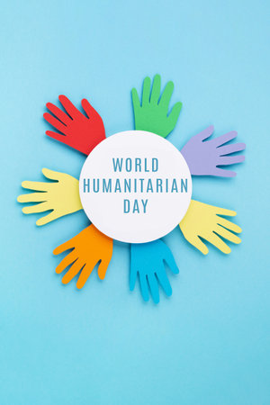 World Humanitarian Day Concept. Tolerance, kindness, cooperative, friendship, charity, humanitarian aid day concept. Paper Hands on blue background, copy space, top view.の写真素材