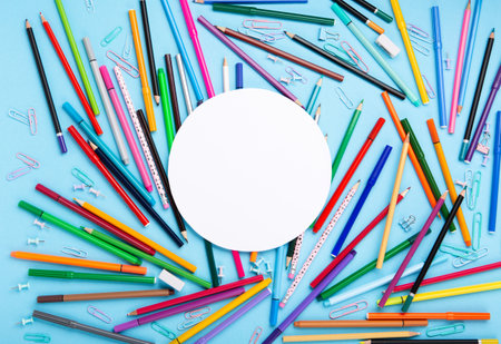 Back to school, Exam, Education concept on blue background. School scattered stationery, notepads, pens, pencils, paper clips on blue table. Top view, copy space.の写真素材