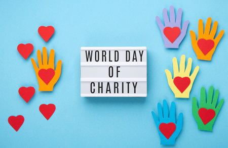 International Day of Charity, 5 September. Tolerance, kindness, cooperative, friendship, charity, humanitarian aid day concept. Colorful hands on blue background, copy space, top view.の写真素材