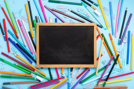 Back to school, Exam, Education concept on blue background. School scattered stationery, notepads, pens, pencils, paper clips on blue table. Top view, copy space.の写真素材