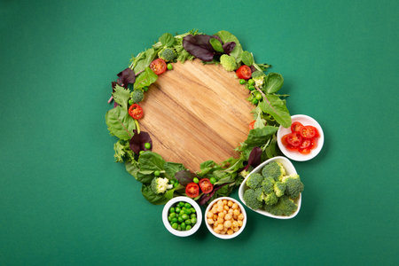Vegetarian and vegan diet month in january called Veganuary. Variety of vegan, plant based protein food, healthy raw vegetables. Top view on green background.の写真素材