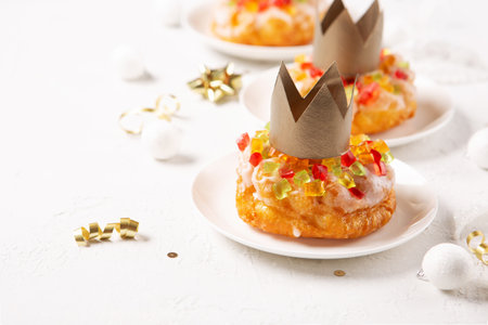 Traditional kings day bread called epiphany cake on white background with winter decorations. Roscon de reyes, spanish three kings Christmas sweet cake. Spanish typical dessert of Epiphany day.の写真素材
