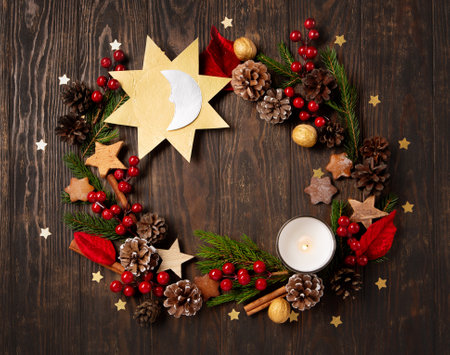 Winter solstice day, December 21. Longest night in the year concept. Sun and moon symbol, Christmas trees, pine cones, paddub branches with red berries, candle on dark wooden background, top view.の写真素材