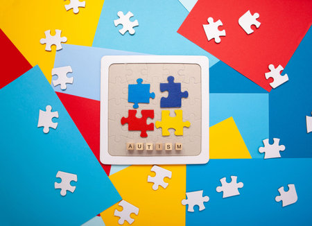 Autism Awareness Day design with colorful and white puzzle pieces on blue background, simple...