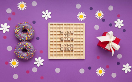 Give to Gain concept for International Women's Day. Two purple donuts, red gift box and spring...
