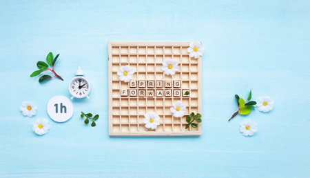 Daylight saving Time, Spring forward, Summer back concept. White Alarm Clock and Spring Daisy...