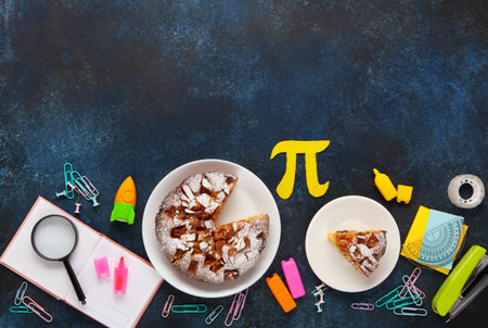 World Pi day. Baked apple pie with Pi Symbol and stationery, dark blue background. March 14th 3.14....