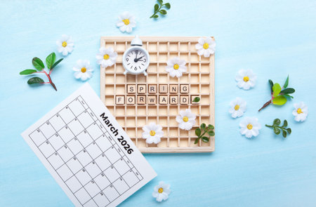 Daylight saving Time, Spring forward, Summer back concept. White Alarm Clock and Spring Daisy...