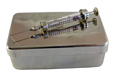 Old syringe on old sterilizing boxの写真素材