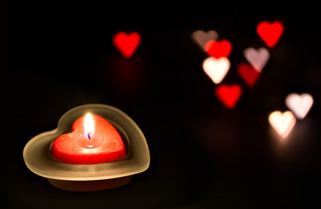 Heart-shaped candle close-up with heart-shaped bokeh for Valentines's dayの写真素材