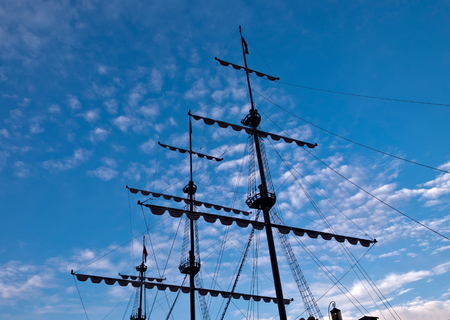 Sailing masts silhouette against blue sky