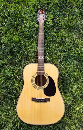 Acoustic Guitar on the grass isolated.の写真素材