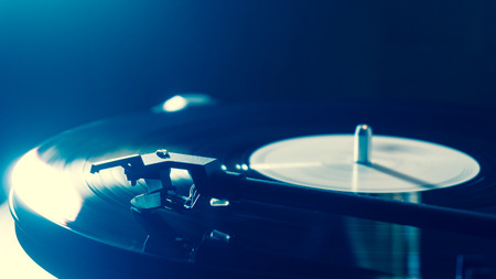 Vintage record player with vinyl disc, close-up. blue lighting