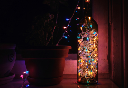 colorful garlands in the bottle against the window. atmospheric light bulbsの写真素材