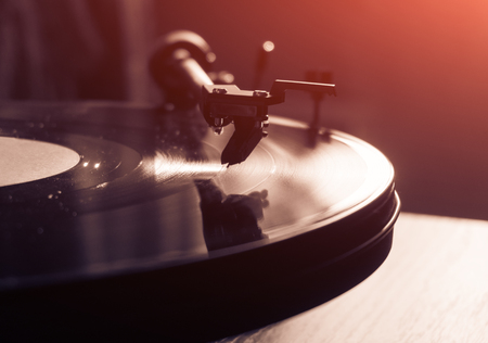 Vintage record player with vinyl disc, close-up. warm sunlightの写真素材
