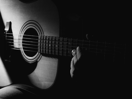 GUITARIST PLAYS ON THE ACOUSTIC GUITAR ON THE STAGE.の写真素材