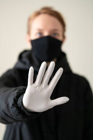 girl in protective gloves shows a stop sign with a hand. epidemic. close-upの写真素材