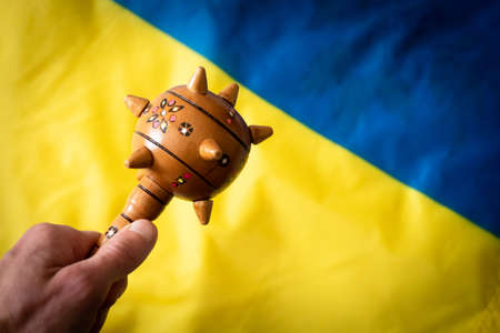 mace weapon in hand against the background of the Ukrainian flag. close-upの写真素材