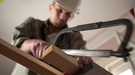 male craftsman works in a workshop with wood. sawing a plank.の写真素材