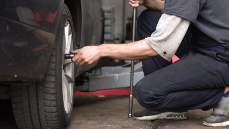 auto mechanic spins the wheel of the car. car workshop.の写真素材