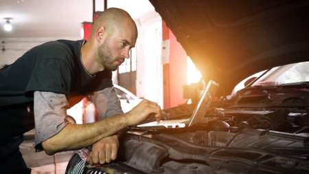 auto mechanic diagnoses a car using a computer. car workshop. close-upの写真素材