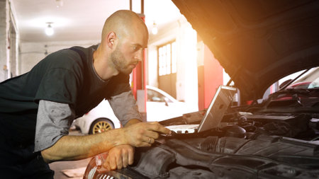 auto mechanic diagnoses a car using a computer. car workshop. close-upの写真素材
