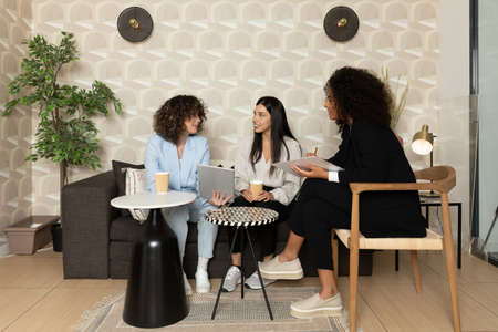 Happy business women sitting in a couch in the office and working together. Office concept.の写真素材
