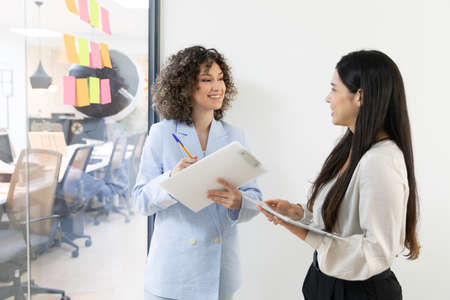 Happy business women sitting in a couch in the office and working together. Office concept.の写真素材